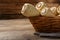 Wicker basket with delicious fresh ripe parsnips on wooden table, closeup. Space for text