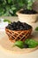 Wicker basket of delicious ripe black mulberries on white table