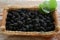Wicker basket with delicious ripe black mulberries on wooden table