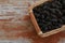 Wicker basket with delicious ripe black mulberries on wooden table, top view. Space for text