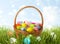 Wicker basket with festively decorated Easter eggs in green grass on sunny day