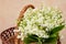 Wicker basket of fresh lily of the valley close up