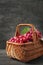 Wicker basket with fresh red grapes on grey background