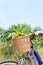 Wicker basket full of flowers on bike handlebars in summer