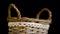Wicker basket with lace strip turns on black background
