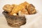 wicker basket overflowing with freshly baked pastries: cheese and poppy seed buns, pretzels, and sweet curd tarts