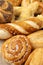 wicker basket overflowing with freshly baked pastries: cheese and poppy seed buns, pretzels, and sweet curd tarts