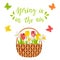 Wicker basket with spring flowers, tulips, daffodils, dragonfly, bee, butterflies. The words Spring is in the air. Bright color