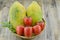 Wicker basket with sweet papaya and ripe persimmon on wooden table