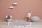 Wicker basket, toys and pouf near pink wall indoors. Interior design