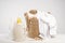 A wicker basket with white linen, clothesline, clothespins, washing gel and fabric softener on a white table. Mockup laundry day