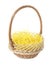 Wicker basket with yellow filler isolated on white. Easter item