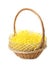 Wicker basket with yellow filler isolated on white. Easter item