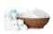 Wicker bowl with disposable diapers, child`s booties and bottles on background