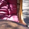 Wicker chair with pink pillows on a summer veranda in a cafe