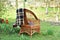 Wicker chair with a warm plaid blanket near the garden house.