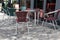 Wicker chairs and metal tables on pavement sidewalk