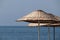 Wicker parasols on blue sea background