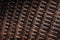 Wicker texture in dark brown tones. Bound stripes made of artificial plastic material