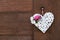 Wicker white heart with peony and daisies hanging on a wooden wall