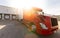 Wide angle of American Semi Truck parked at the dock. Tucking and logistics with red big rig waiting to get loaded at company. Shi