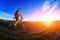 Wide angle of the cyclist standing on the trail on the field against beautiful landscape.