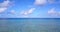 Wide angle flying travel shot of a white paradise beach and blue water background in vibrant 4K