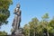 Wide Angle Front Right Buddha Pacifying Relatives Statue on Blue Sky Background