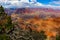 Wide angle of Grand Canyon with beautiful blue cloudy sky and gnarled pine branches in foreground - selective focus