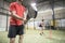 Wide angle image of couple training in paddle tennis class behind cones