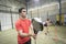 Wide angle image of couple training in paddle tennis class behind cones