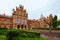 Wide-angle landscape of Chernivtsi University. Ancient brown brick building with front yard.