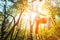 Wide angle male tightrope walker balancing barefoot on slackline in autumn forest. The concept of outdoor sports and