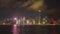 A wide angle night view of victoria harbour and buildings with spotlights during a light show- as seen from tsim sha tsui