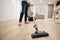 Wide angle photo of woman housewife or maid or service worker hoovering with vacuum cleaner in bright luxury appartment.