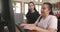 Wide angle shot of Asian women co-workers in office workplace including person with blindness disability using computer with