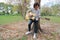 Wide angle shot. Guitarist man with headphones standing and playing acoustic guitar in outdoor park.