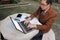 Wide angle shot of handsome yong business man is using laptop with blank screen for his work at outdoor.