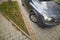 Wide angle shot of modern silver car parked on paved sunny quiet suburban street on sunny day. Transportation, comfort, speed