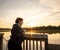 Wide angle shot of an older woman at sunrise with Coffee