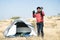 Wide angle shot of Young traveller busy talking with camera on top of Mountain in front of camping tent - Concept of travel