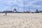 Wide angle view of the beach, with a woman walking a dog. Jolly Roger Amusement park in