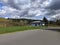 Wide angle view of a biker gearing back up on their bicycle after taking a break at a park bench on a sunny, cloudy day