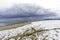 Wide angle view of driftwood on snow covered beach, approaching