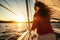 Wide angle view of a female riding on sailing boat at sunset. Water sports. Summer tropical vacation concept.