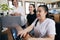 Wide angle view of happy Asian women co-workers in office workplace including person with blindness disability using computer with