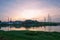 Wide angle view of industry factory building with smoke and steam from smokestack reflect on river against twilight sky