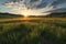 wide-angle view of sun setting over grassy plains