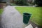 Wide angle view of trash can by a path in a park