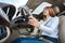 Wide angle view of young redhead woman driver fastened by seatbelt driving a car smiling happily